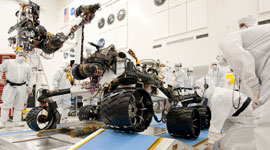 Test operators monitor how NASA's Mars rover Curiosity handles driving over a ramp during a test inside the Spacecraft Assembly Facility at NASA's Jet Propulsion Laboratory